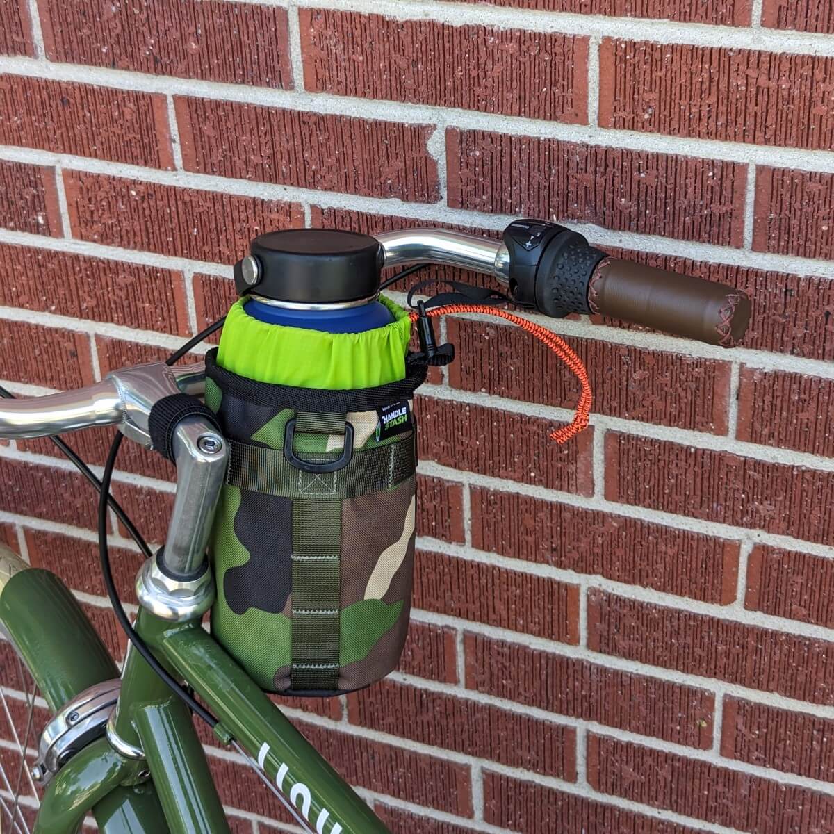 Camouflage bike stem bag with green liner on bicycle handlebars.