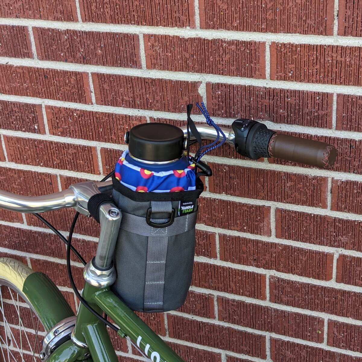 Charcoal stem bag with Colorado Flag liner holding a large water bottle on a bike.